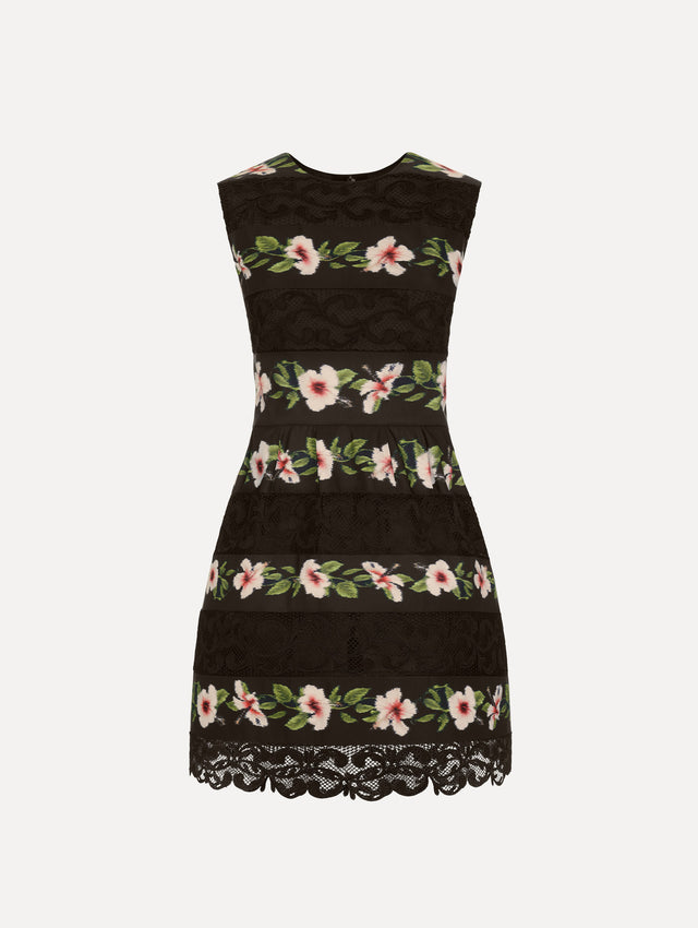 The Chiné Hibiscus Striped Faille Dress in Black. Featuring woven hibiscus motifs alternating with panels of faille and guipure lace, creating a striped pattern. Mini length. Front View.