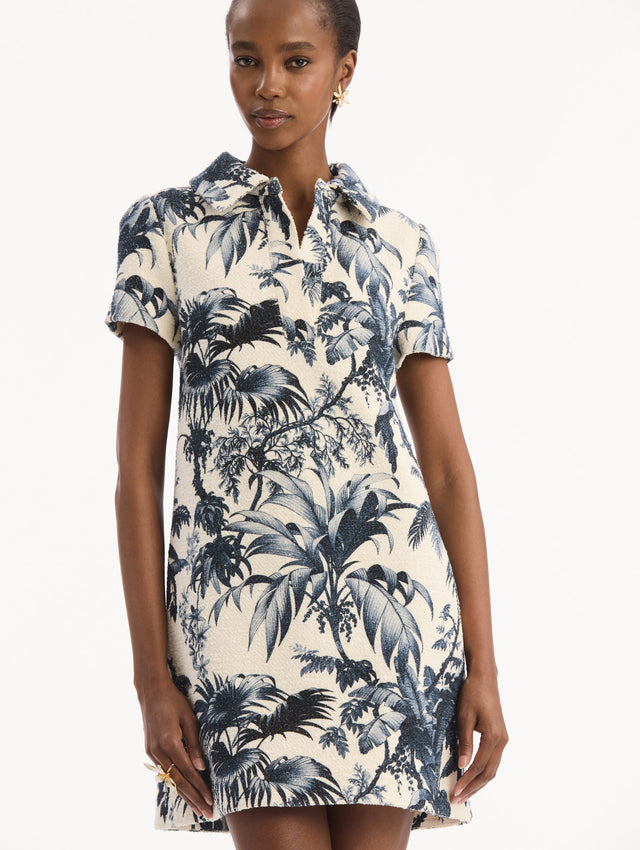 The model is wearing the Chiné Palm Leaves Shift Dress in ivory printed with navy palm leaves. Featuring a classic collar neckline, short sleeves, and mini length. Detail View.