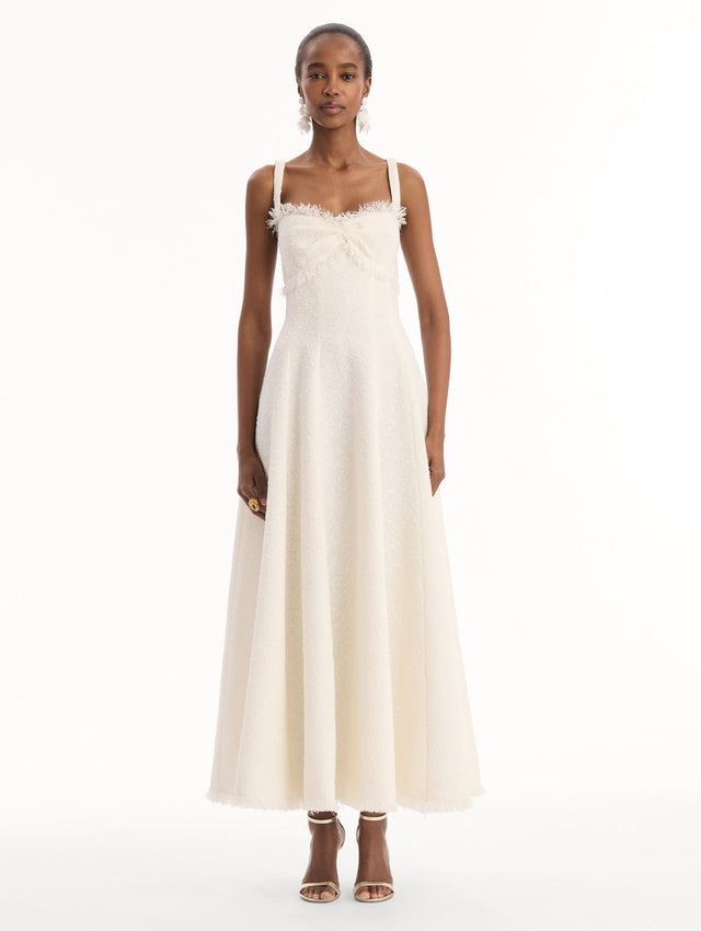 The model is wearing the Slub Wool Tweed Midi Dress in Ivory. Featuring a softly structured silhouette and curved neckline accented with delicate fringe detailing. Front View.
