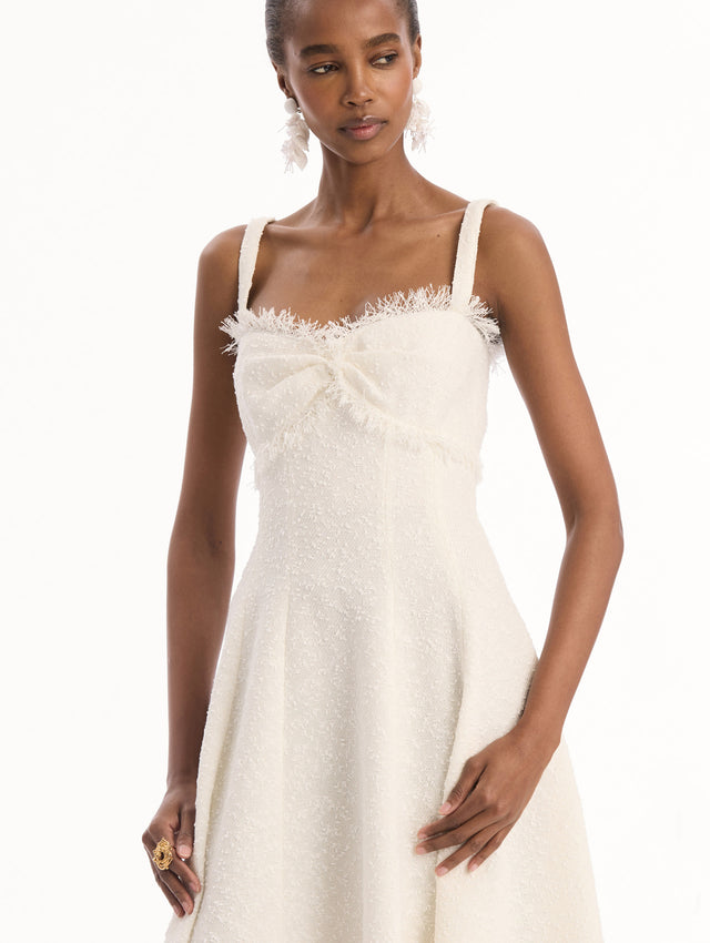 The model is wearing the Slub Wool Tweed Midi Dress in Ivory. Featuring a softly structured silhouette and curved neckline accented with delicate fringe detailing. Detail View.