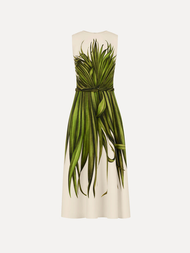 The model is wearing the Palm Leaves Wool-Blend Dress in ivory printed with green palm leaves. Featuring a belt at waist and midi-length skirt. Front View.