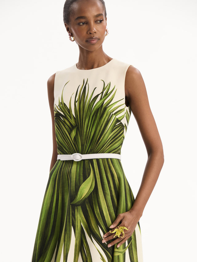 The model is wearing the Palm Leaves Wool-Blend Dress in ivory printed with green palm leaves. Featuring a belt at waist and midi-length skirt. Detail View.
