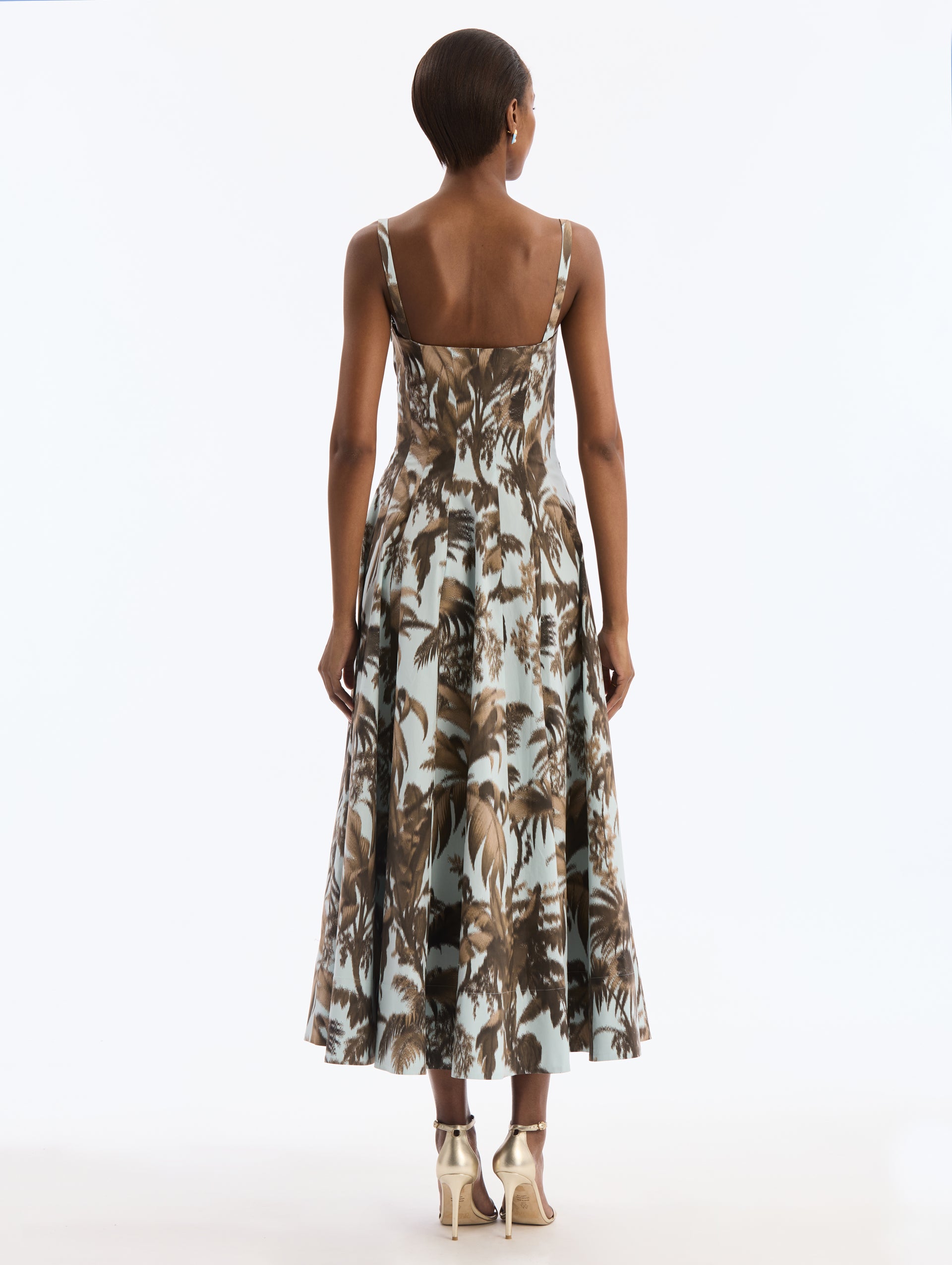 Blue Cotton Poplin Dress with Brown Chiné Palm Leaves. Delicate straps. Corseted Bodice, Pleated Skirt. Back View.