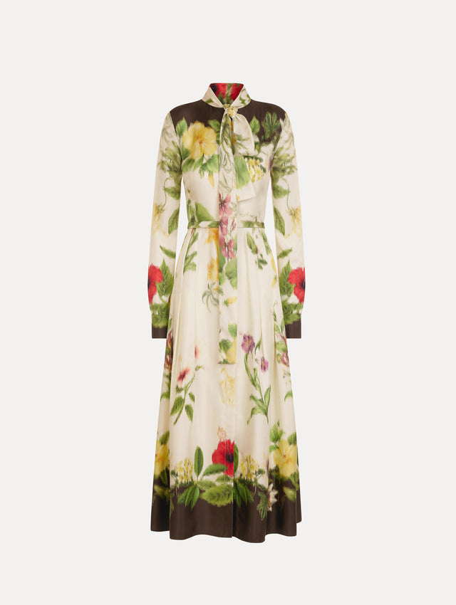 The Chiné Dominican Mixed-Floral Silk Twill Dress. Featuring a vibrant array of Dominican florals, tie neckline, belt at waist, long sleeves, and a midi length. Front View.