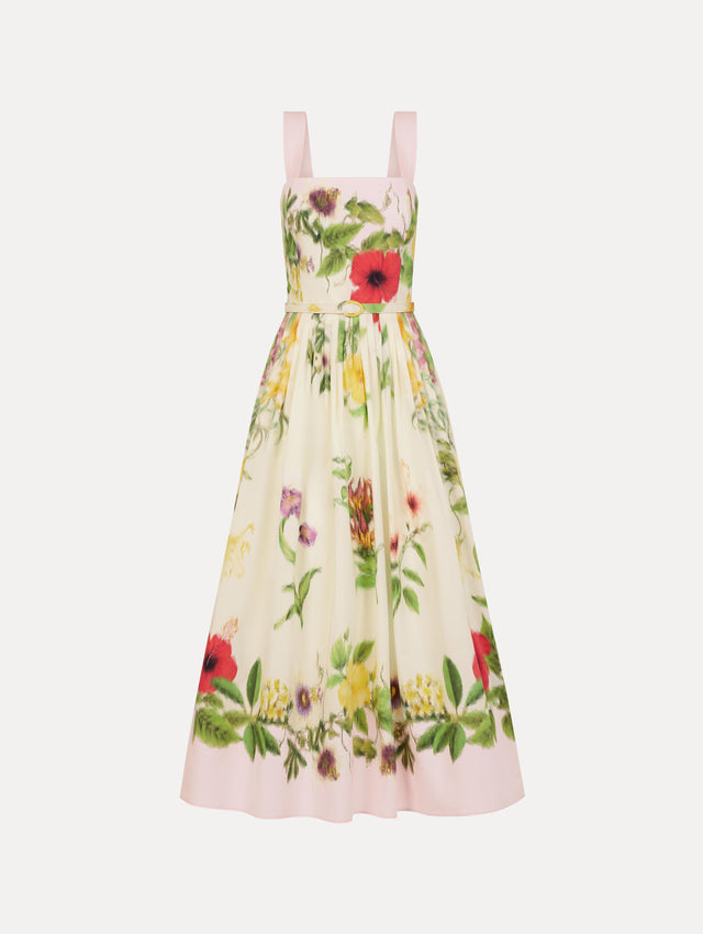 The Dominican Mixed-Floral Cotton Poplin Dress in ivory printed with an array of Dominican florals and light pink at the trims. Featuring a square neckline with tank straps, belt at waist, and pleated midi skirt. Front View.