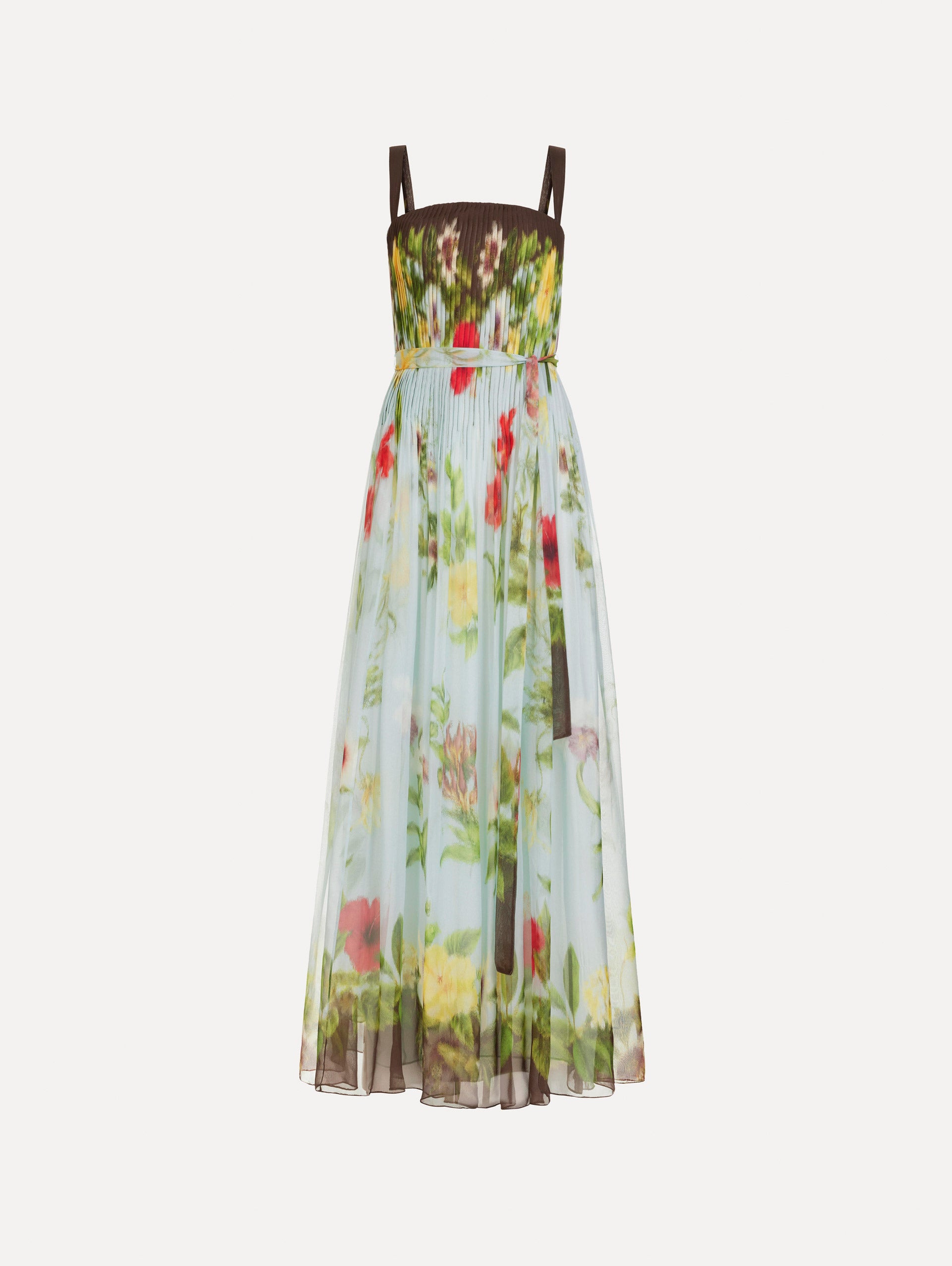 The Dominican Mixed-Floral Silk Chiffon Gown in light blue printed with an array of Dominican florals and brown at the trims. Featuring a pleated bodice, tank straps, tie at waist, and long, flowing skirt. Front View.