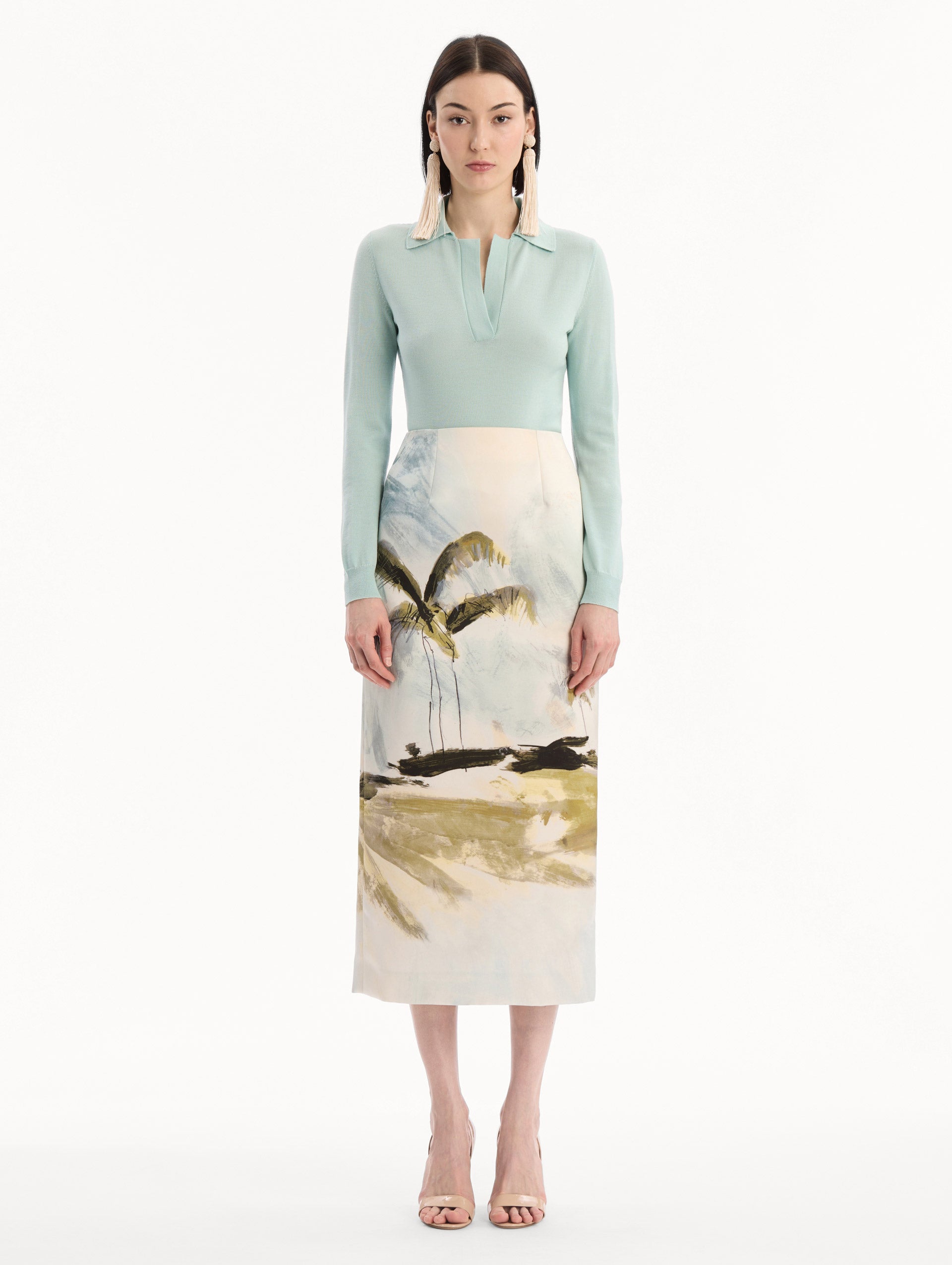 The model is wearing the Dominican Landscape Pencil Skirt printed in the Dominican landscape. Featuring a structured, column silhouette and midi length. Front View.
