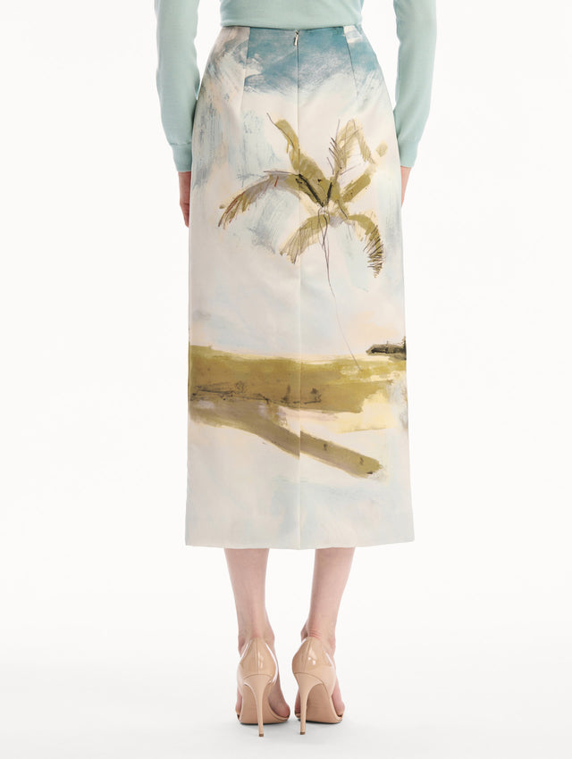 The model is wearing the Dominican Landscape Pencil Skirt printed in the Dominican landscape. Featuring a structured, column silhouette and midi length. Back View.