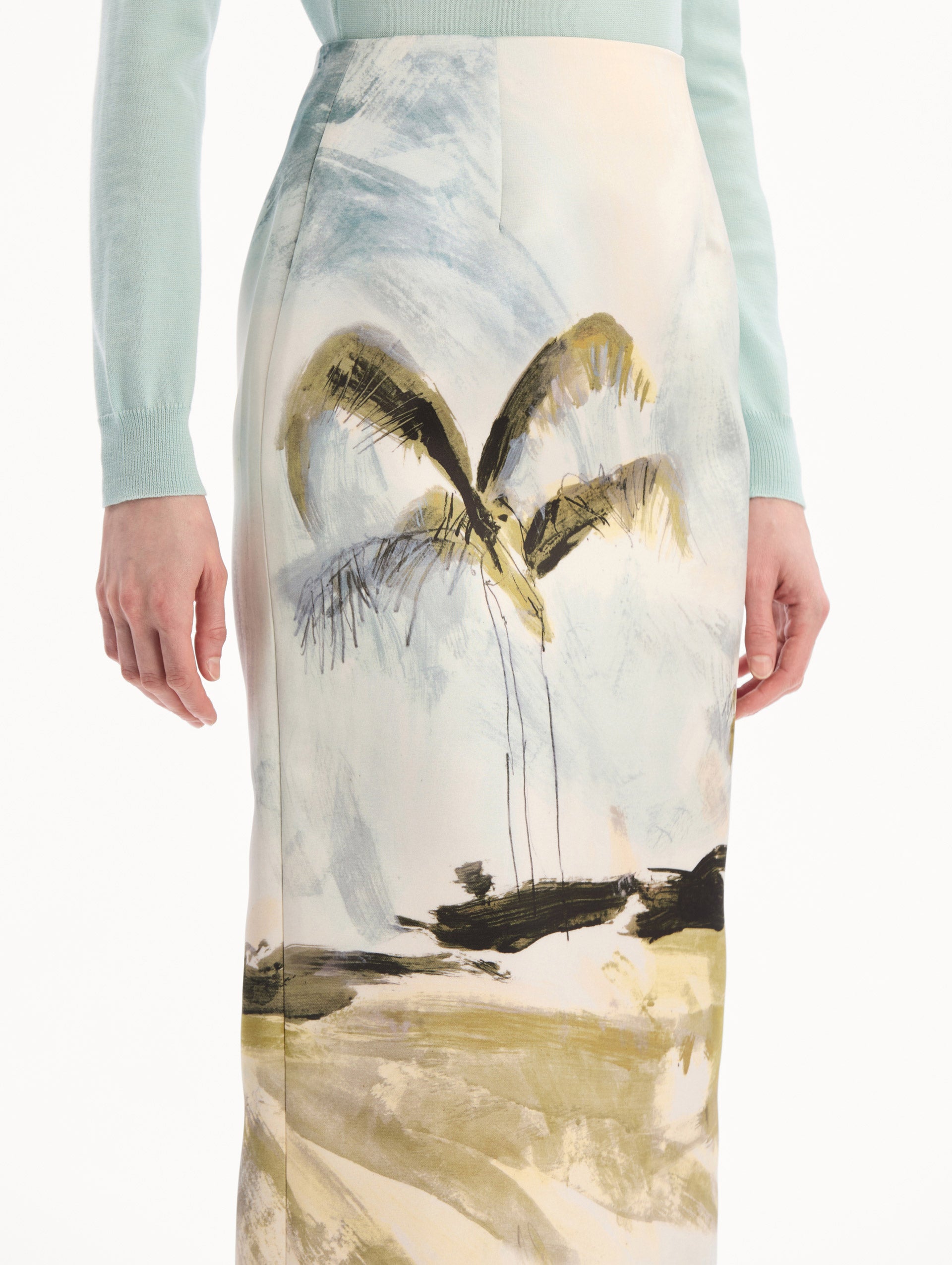 The model is wearing the Dominican Landscape Pencil Skirt printed in the Dominican landscape. Featuring a structured, column silhouette and midi length. Detail View.