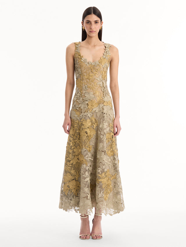 The model is wearing the Hibiscus Metallic Guipure Cocktail Dress in Gold. Featuring metallic guipure lace, a fitted bodice, and softly flared skirt. Front View.