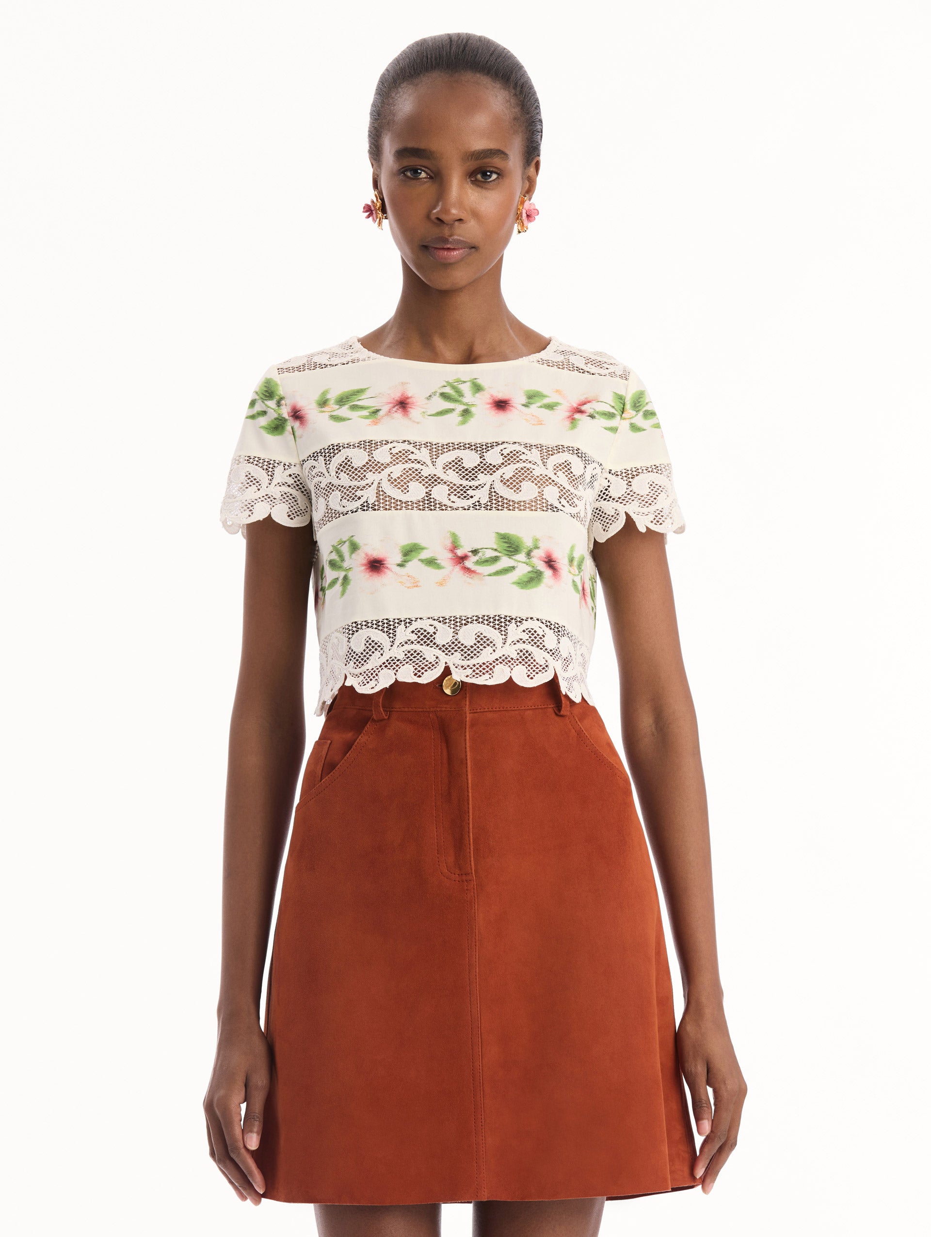 The model is wearing the chiné hibiscus striped cotton poplin blouse with guipure lace panels and a striped floral pattern in the color ivory. Front view.