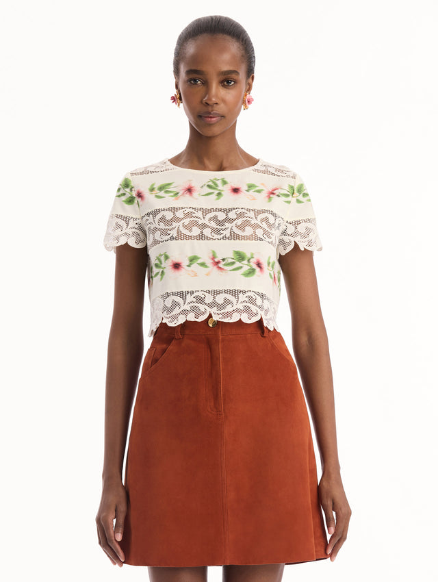 The model is wearing the chiné hibiscus striped cotton poplin blouse with guipure lace panels and a striped floral pattern in the color ivory. Front view.
