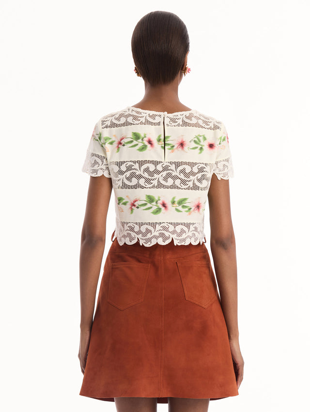 The model is wearing the chiné hibiscus striped cotton poplin blouse with guipure lace panels and a striped floral pattern in the color ivory. Back view.
