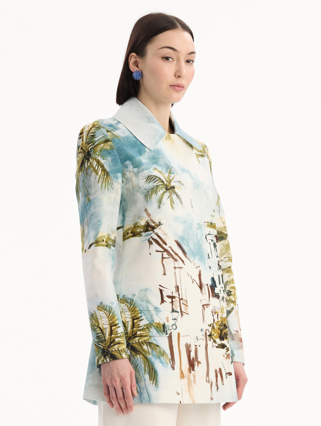 The model is wearing the Dominican Landscape Cotton Poplin Coat featuring an exaggerated collar, hidden buttons, front-flap pockets, and long sleeves. Side View.