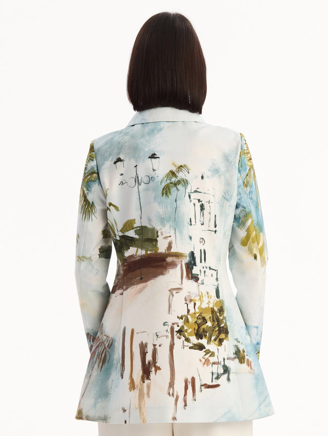 The model is wearing the Dominican Landscape Cotton Poplin Coat featuring an exaggerated collar, hidden buttons, front-flap pockets, and long sleeves. Back View.