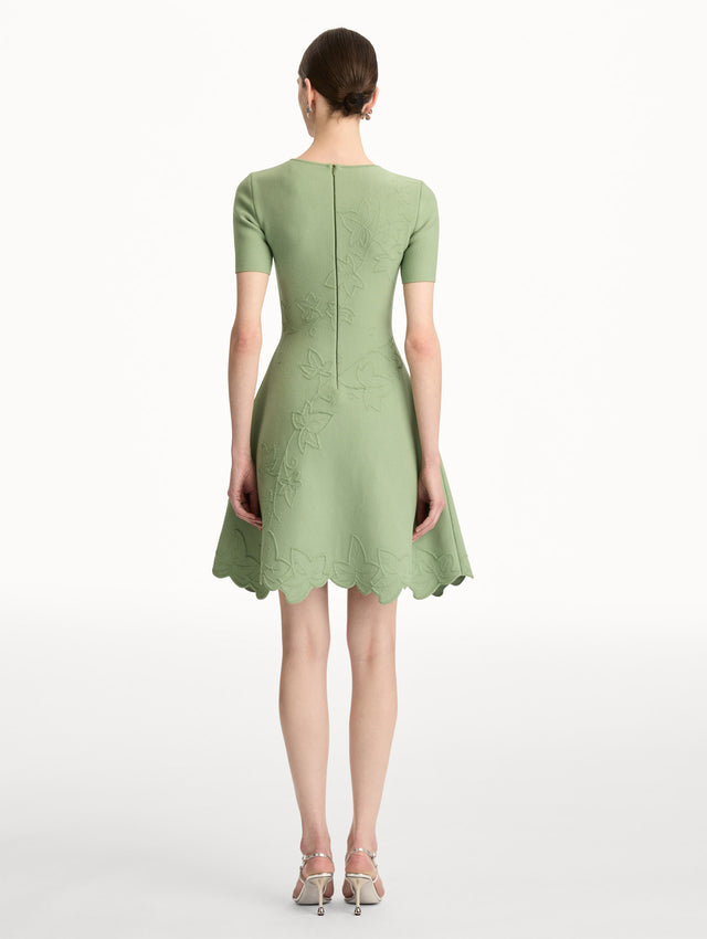Green Ivy Cutout Knit Dress featuring short sleeves, leaf appliqué detailing, and scalloped hem. Back View.