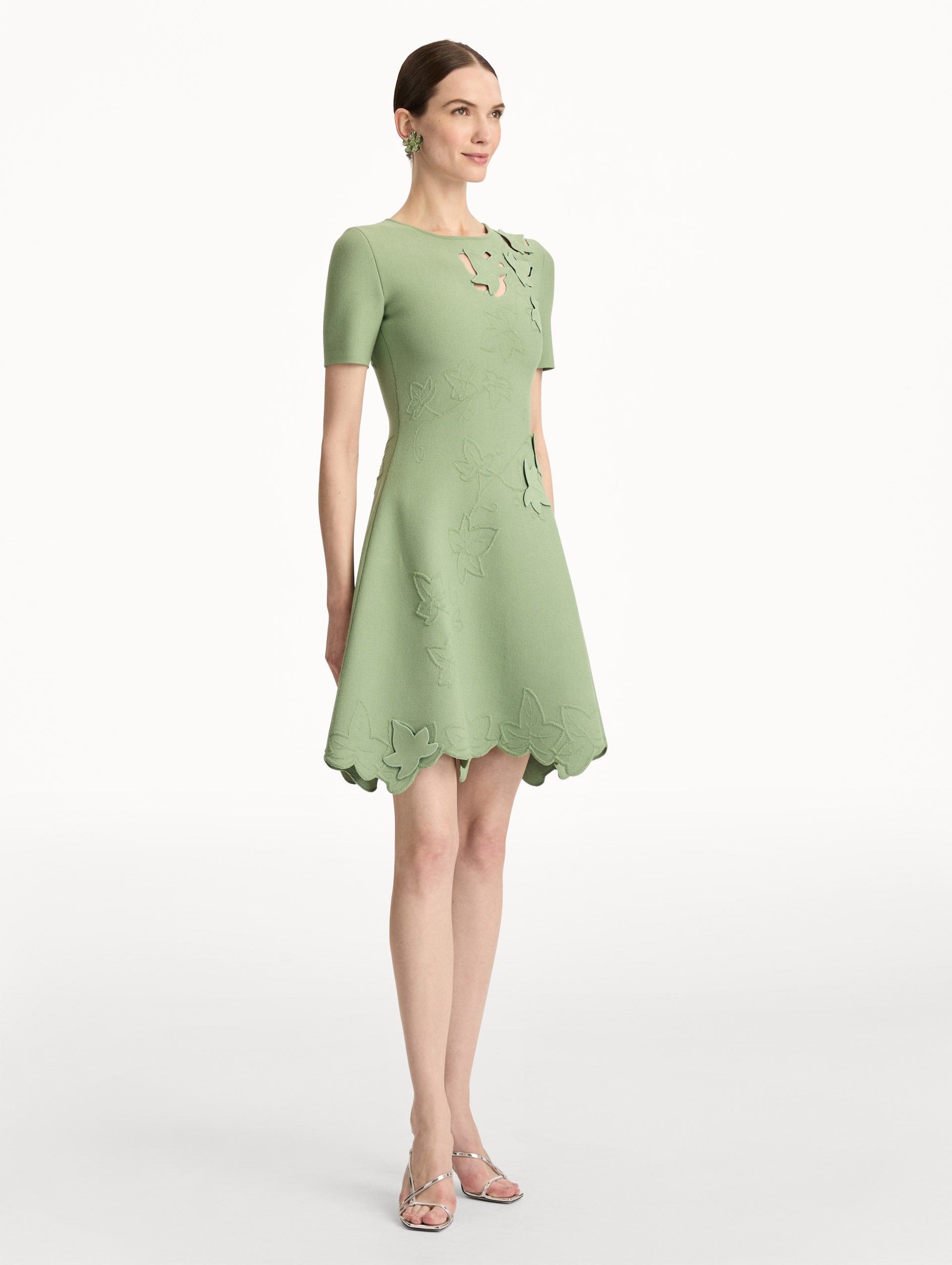 Green Ivy Cutout Knit Dress featuring short sleeves, leaf appliqué detailing, and scalloped hem. Side View.