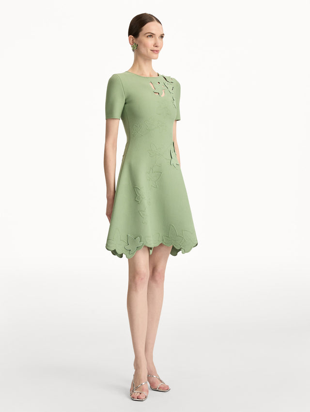 Green Ivy Cutout Knit Dress featuring short sleeves, leaf appliqué detailing, and scalloped hem. Side View.