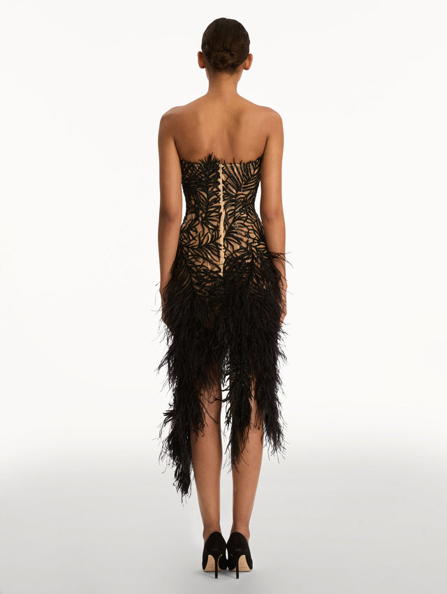 Black Feather Embroidered Cocktail Dress with strapless embroidered bodice, feathered hemline, and asymmetrical skirt. Back View.