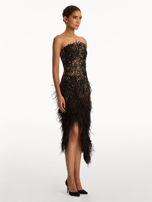 Black Feather Embroidered Cocktail Dress with strapless embroidered bodice, feathered hemline, and asymmetrical skirt. Side View.