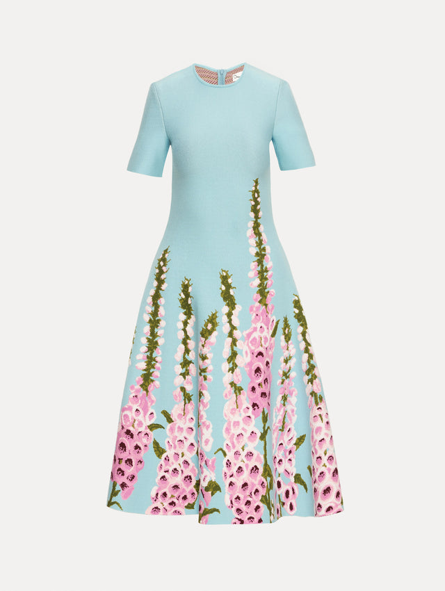 Blue Foxglove Jacquard Knit Dress with short sleeves, a fitted bodice, flared skirt, and pink foxglove floral embroidery cascading from the hem upward.