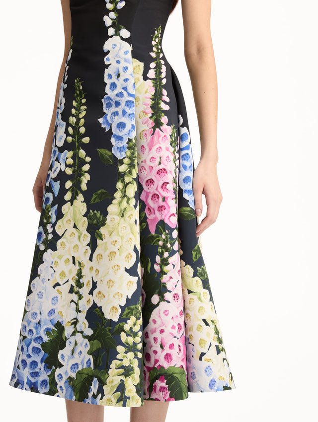Black Degradé Foxglove Faille Dress featuring a fitted bodice, scoop neckline, and a flared skirt with multicolor foxglove floral print. Zoom View.