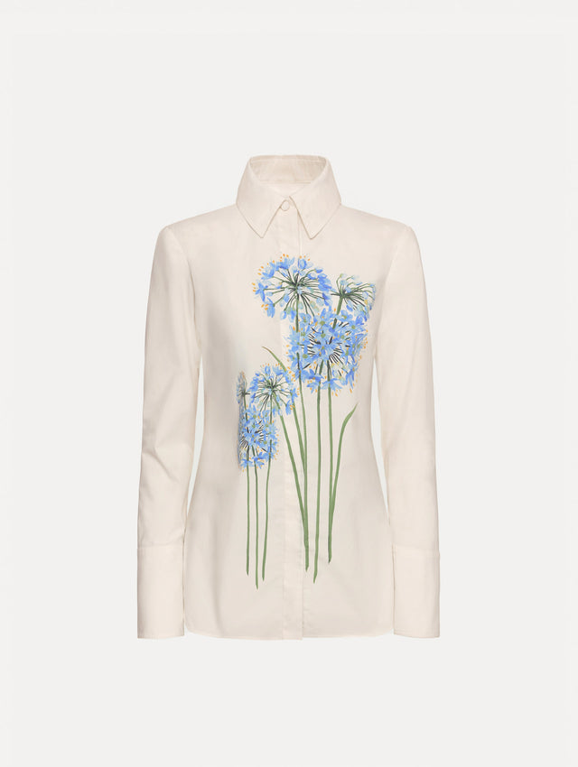 Ivory Allium Cotton Poplin Blouse with long sleeves and blue floral embroidery on the front.
