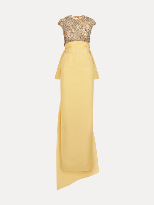 Yellow floor length gown with crystal porcelain flowers on an open back sculpted bodice. Dramatic faille skirt with cascading peplum train. Front View.