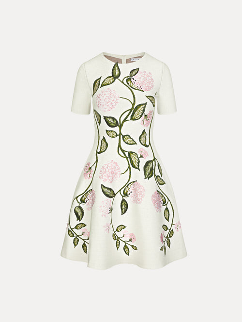 Mini dress in the color white with short sleeves and embroidered floral motif.