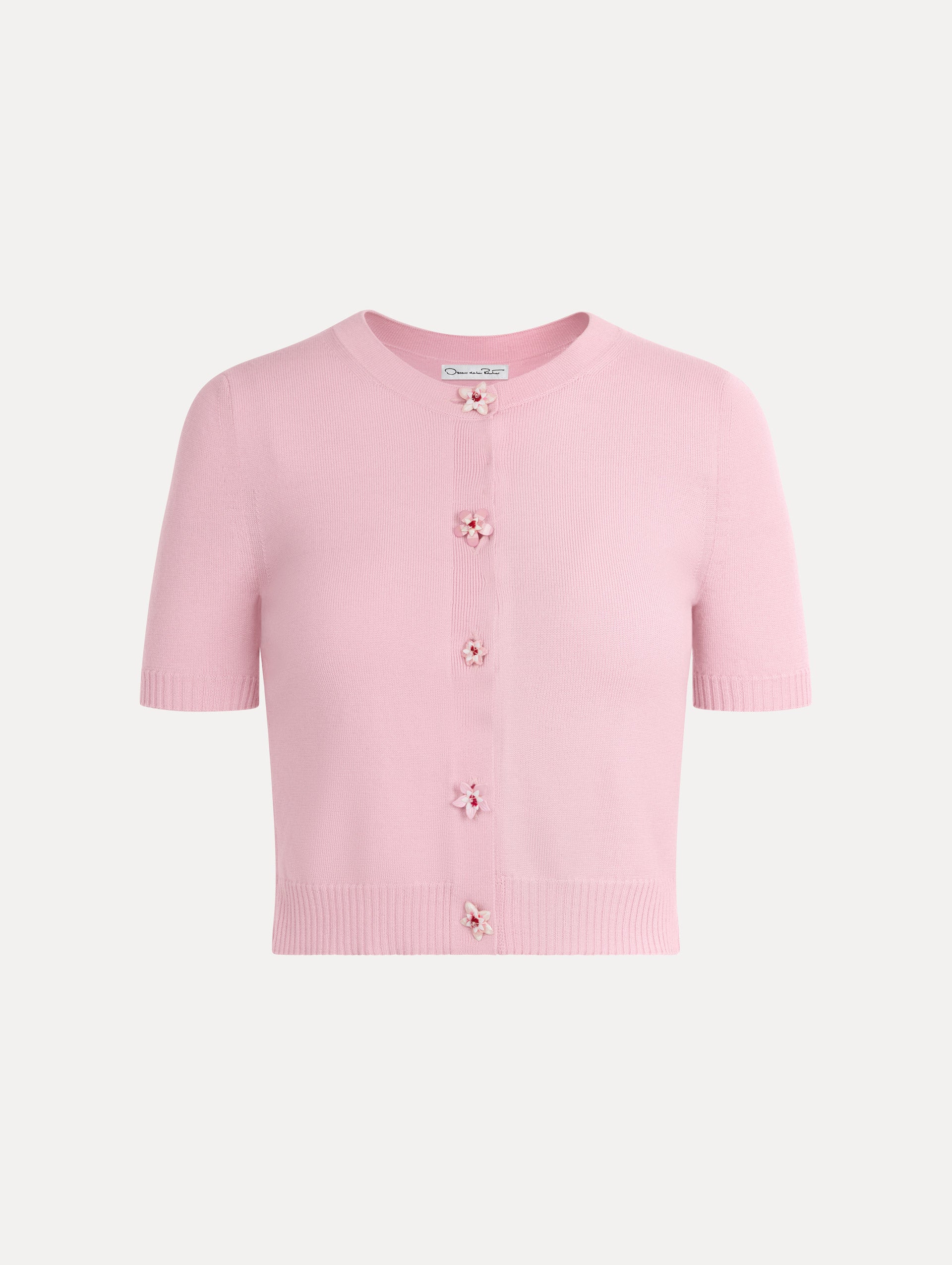 Knit short sleeve cardigan in the color light pink with ribbed hem and flower button front.