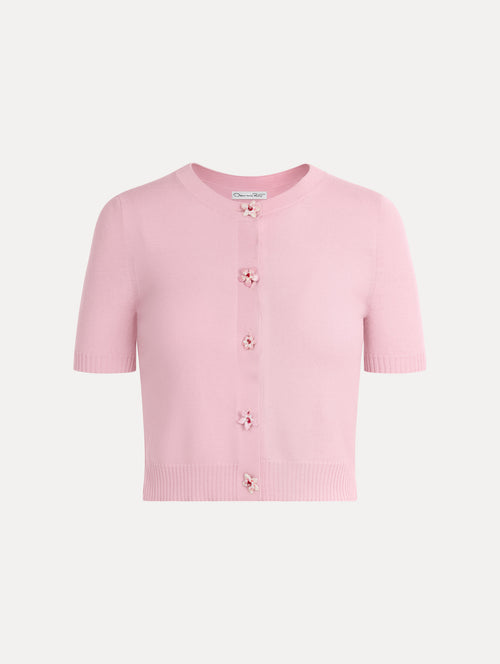 Knit short sleeve cardigan in the color light pink with ribbed hem and flower button front.