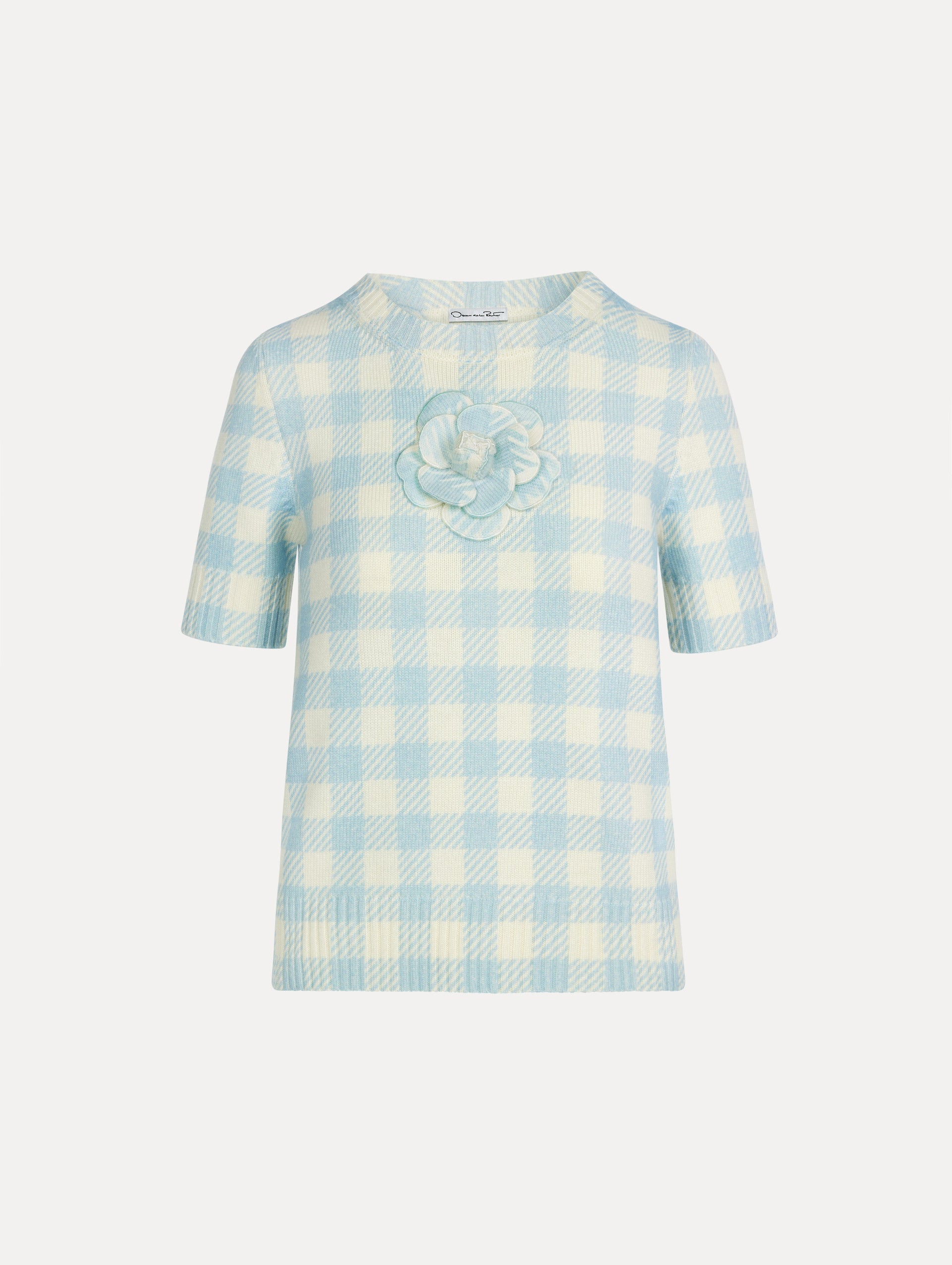 Short sleeve Knit pullover in classic pale blue and white gingham wool. Dimensional floral appliqué at the neckline. Front View. 