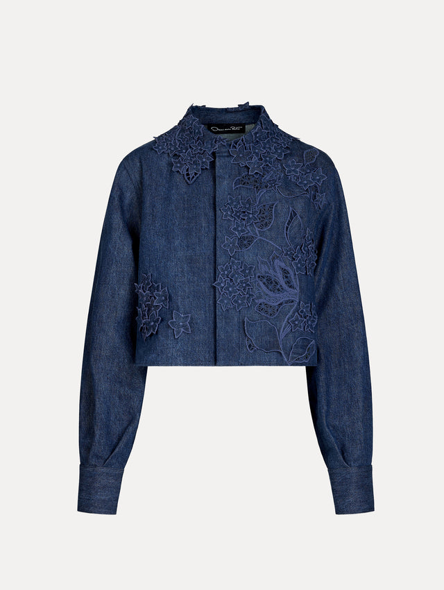 Cropped denim jacket with intricate porcelain flower threadwork and cutout detailing across the front and collar. Long sleeve. Front View.