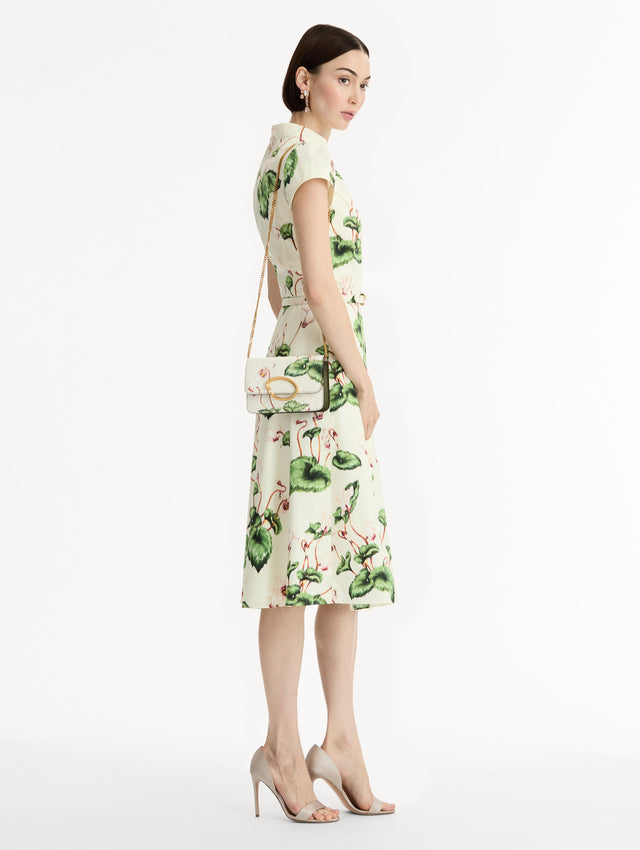 Ivory Cyclamen-Printed O Pochette with green and pink floral motifs and gold hardware. Front View.