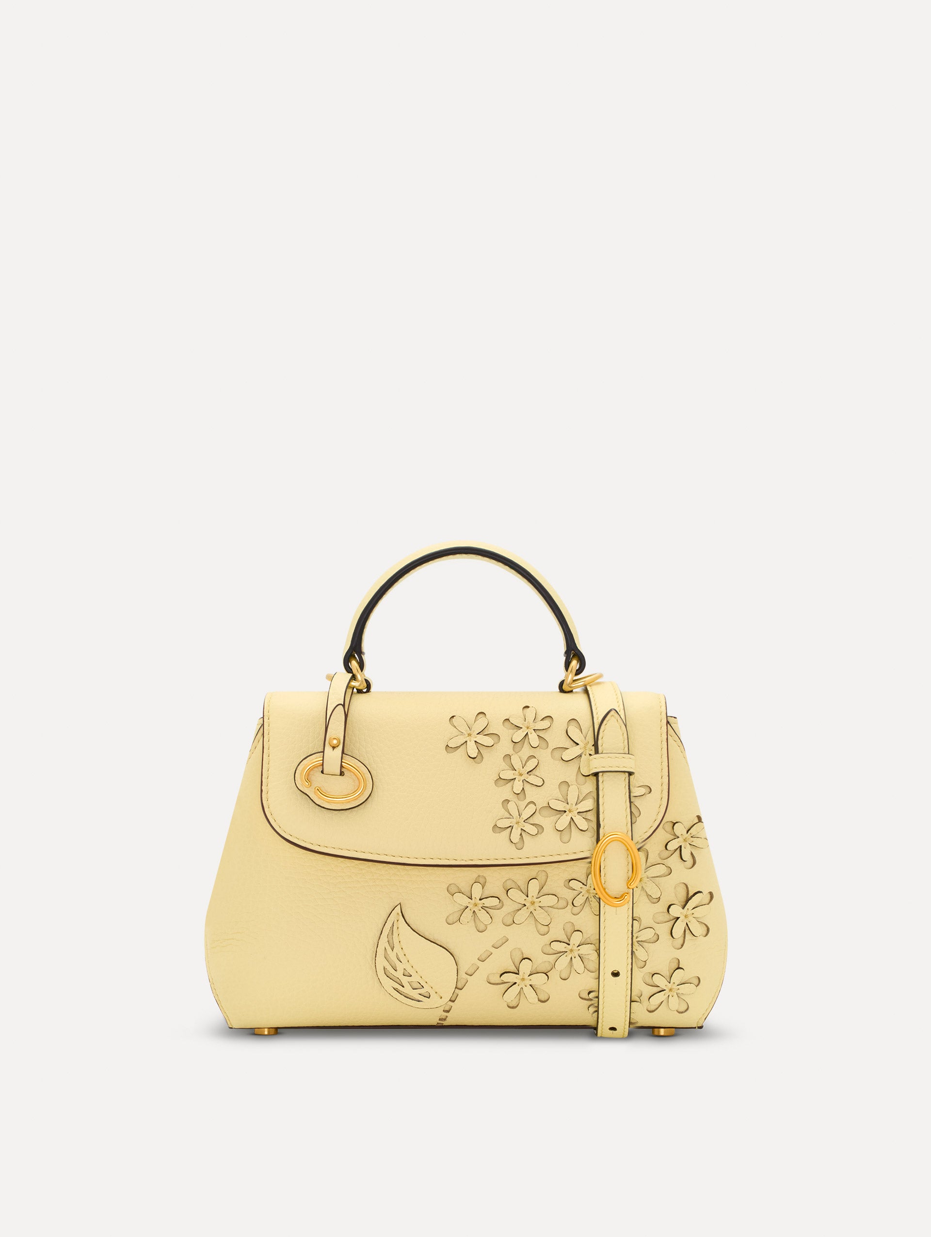 The Mini Poppy in yellow with floral cutout designs and gold hardware. Front View. 