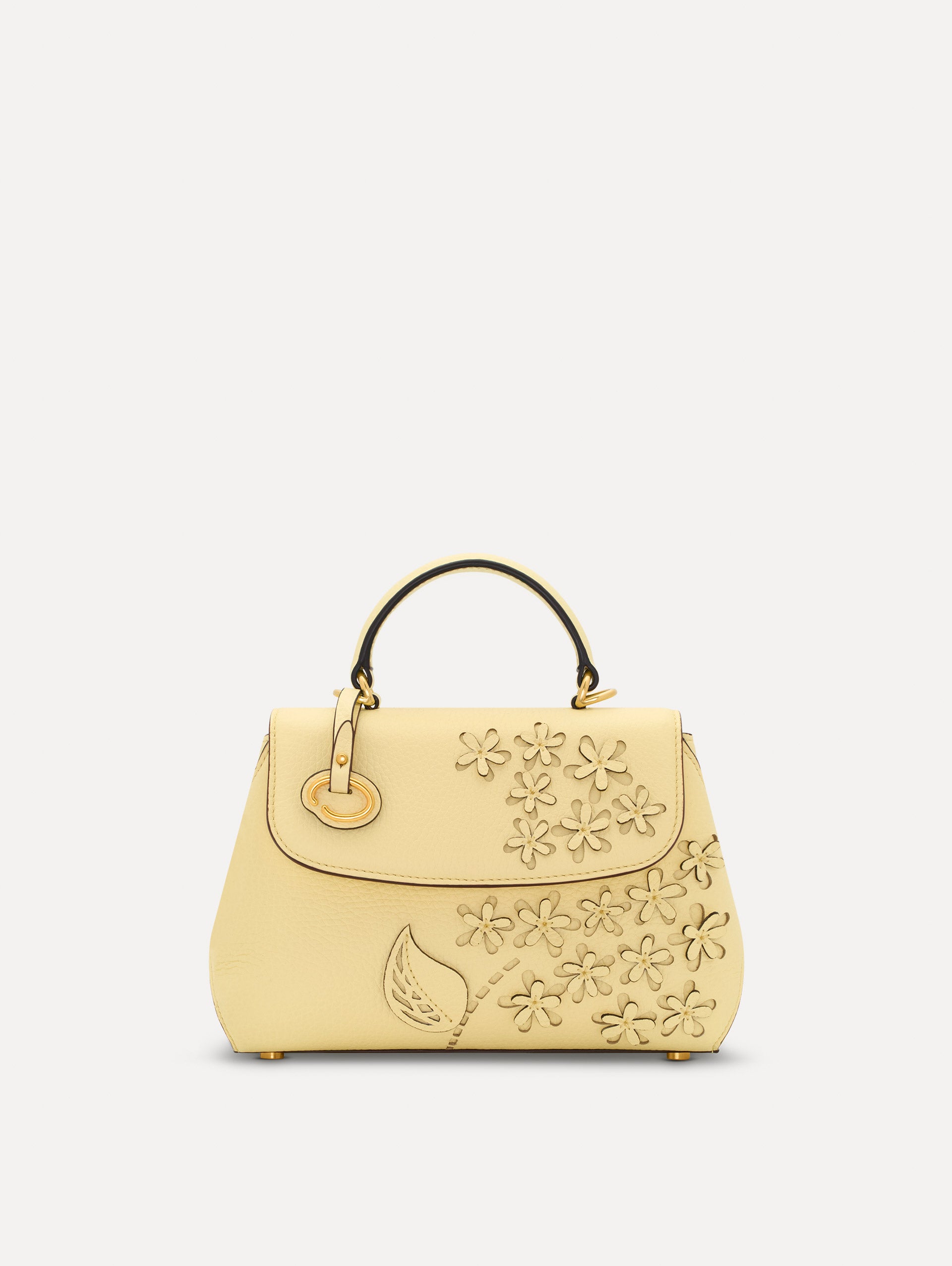 The Mini Poppy in yellow with floral cutout designs and gold hardware. Front View. 