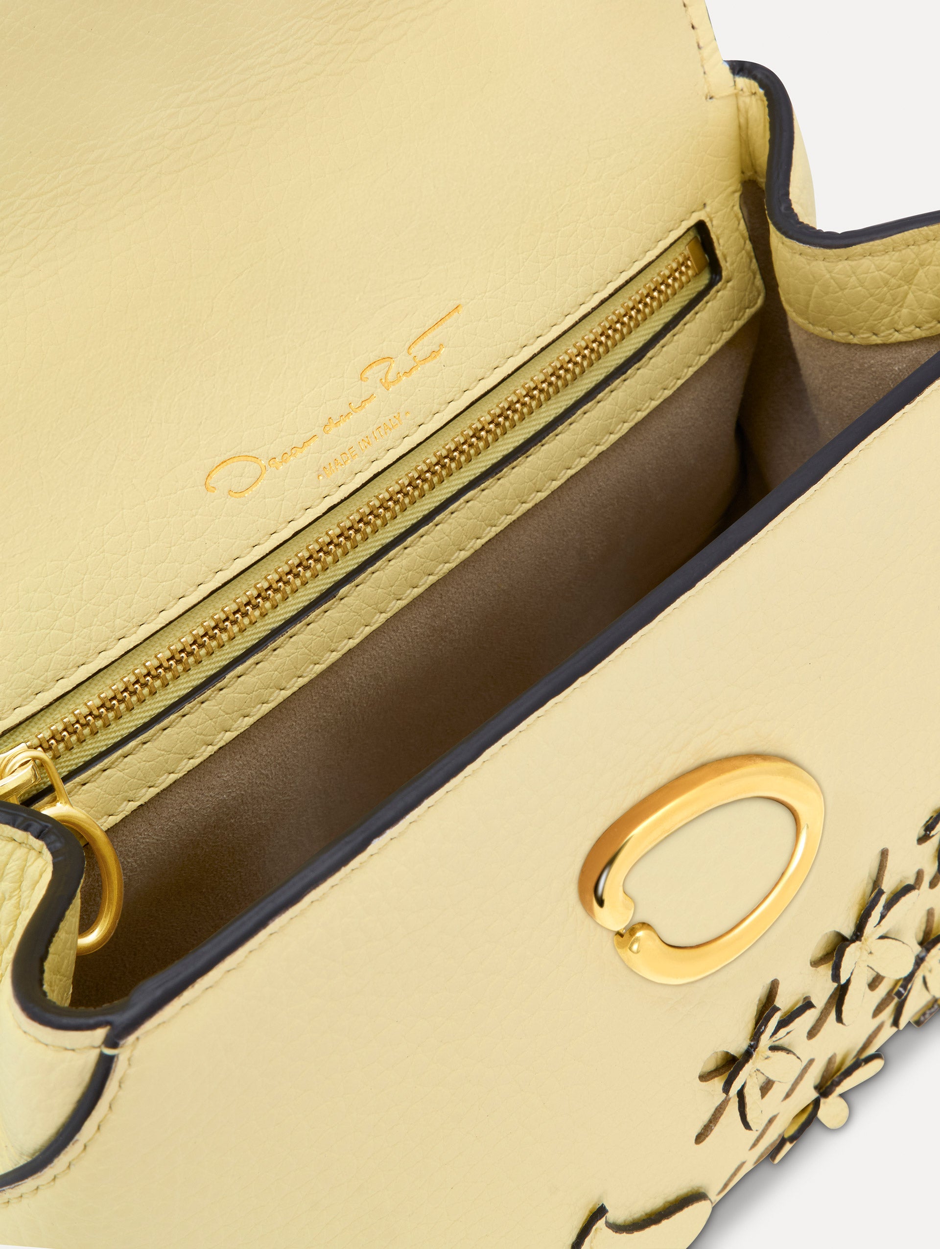 The Mini Poppy in yellow with floral cutout designs and gold hardware. Zoom View. 