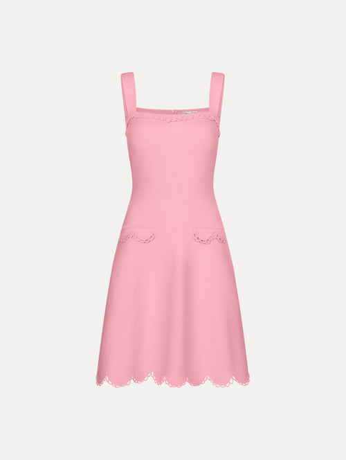 Pink mini dress with thick tank top straps, front flap pockets, and scalloped lace trim.