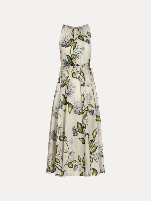 Halter neck, sleeveless, cotton poplin midi dress in off white. Pleated with blue flower print. Subtle bows at waist. Front View.