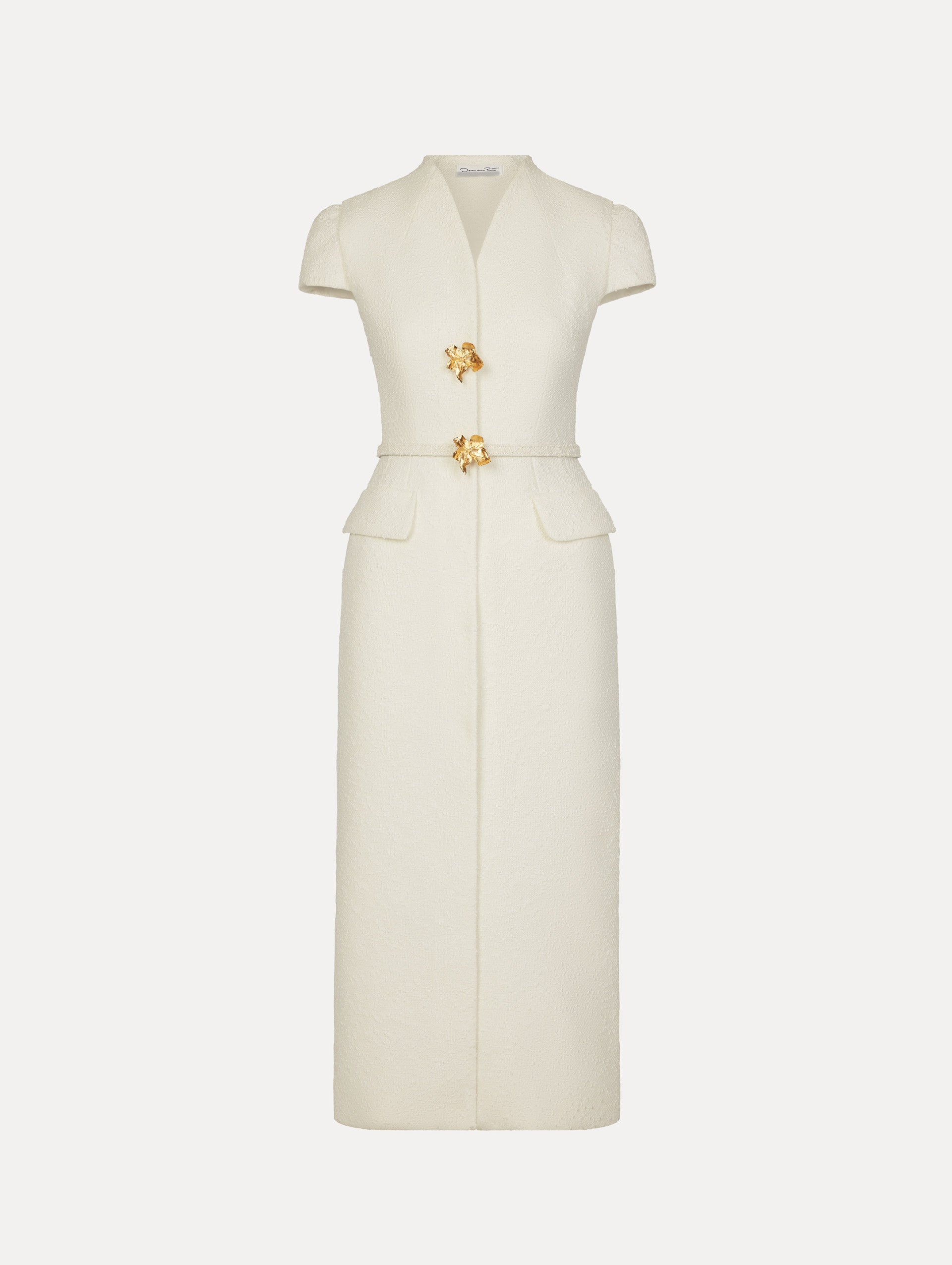Tailored dress in the color white with cap sleeve, front flap pockets, matching belt at waist, and gold flower button front.