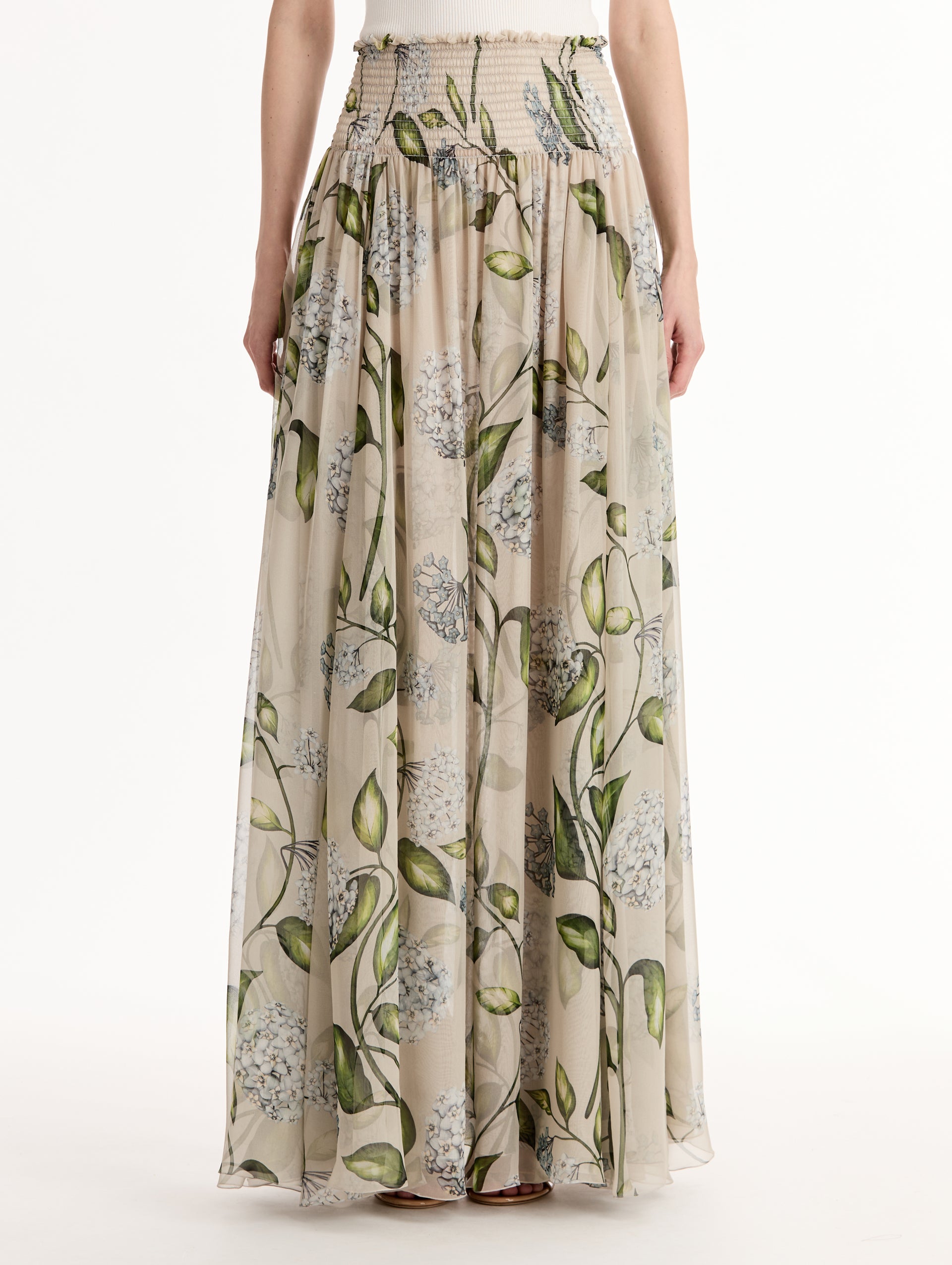 Oatmeal Porcelain Flower Chiffon Maxi Skirt featuring a smocked high waist and a flowing A-line silhouette with green and blue floral print. Front View. 