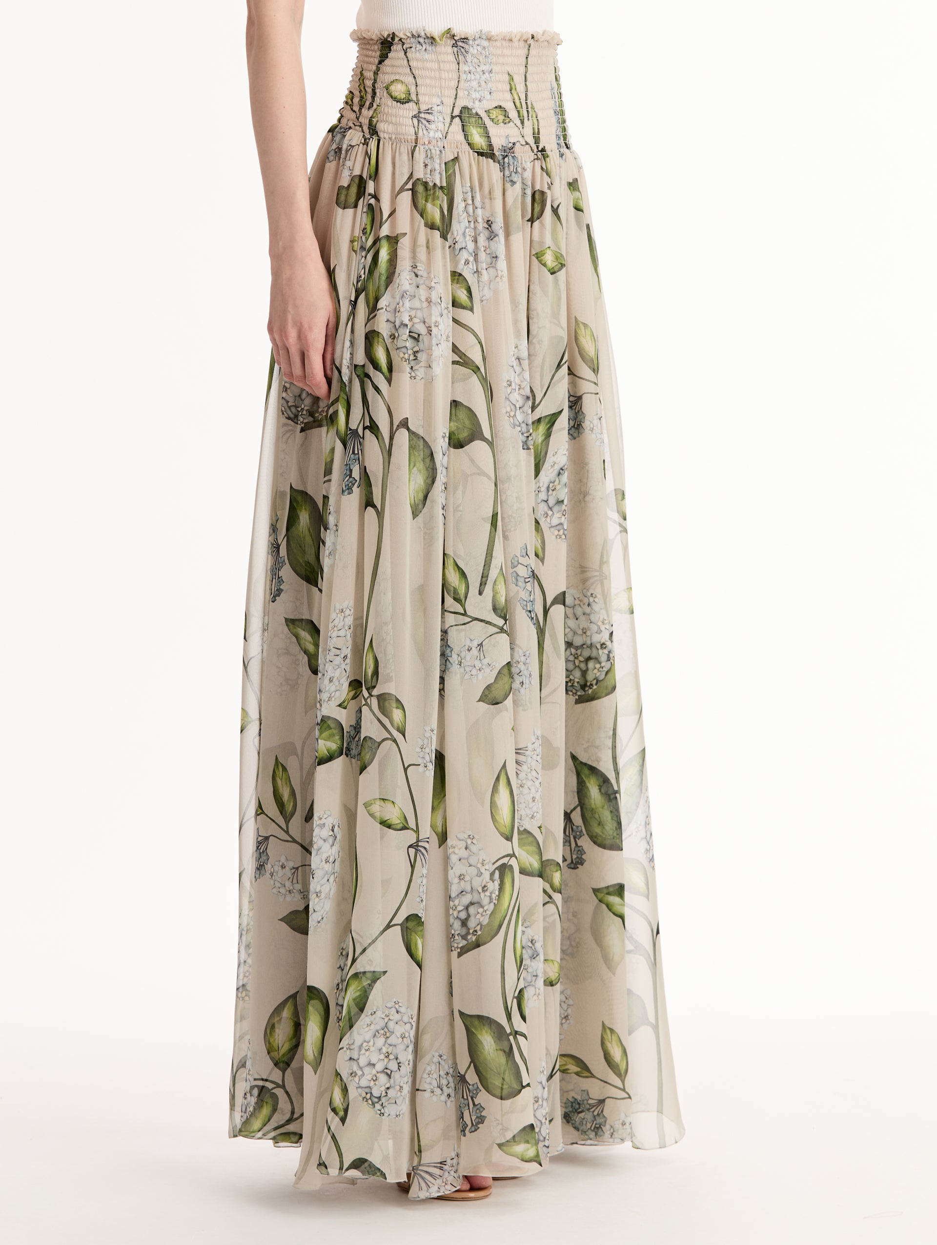 Oatmeal Porcelain Flower Chiffon Maxi Skirt featuring a smocked high waist and a flowing A-line silhouette with green and blue floral print. Side View.