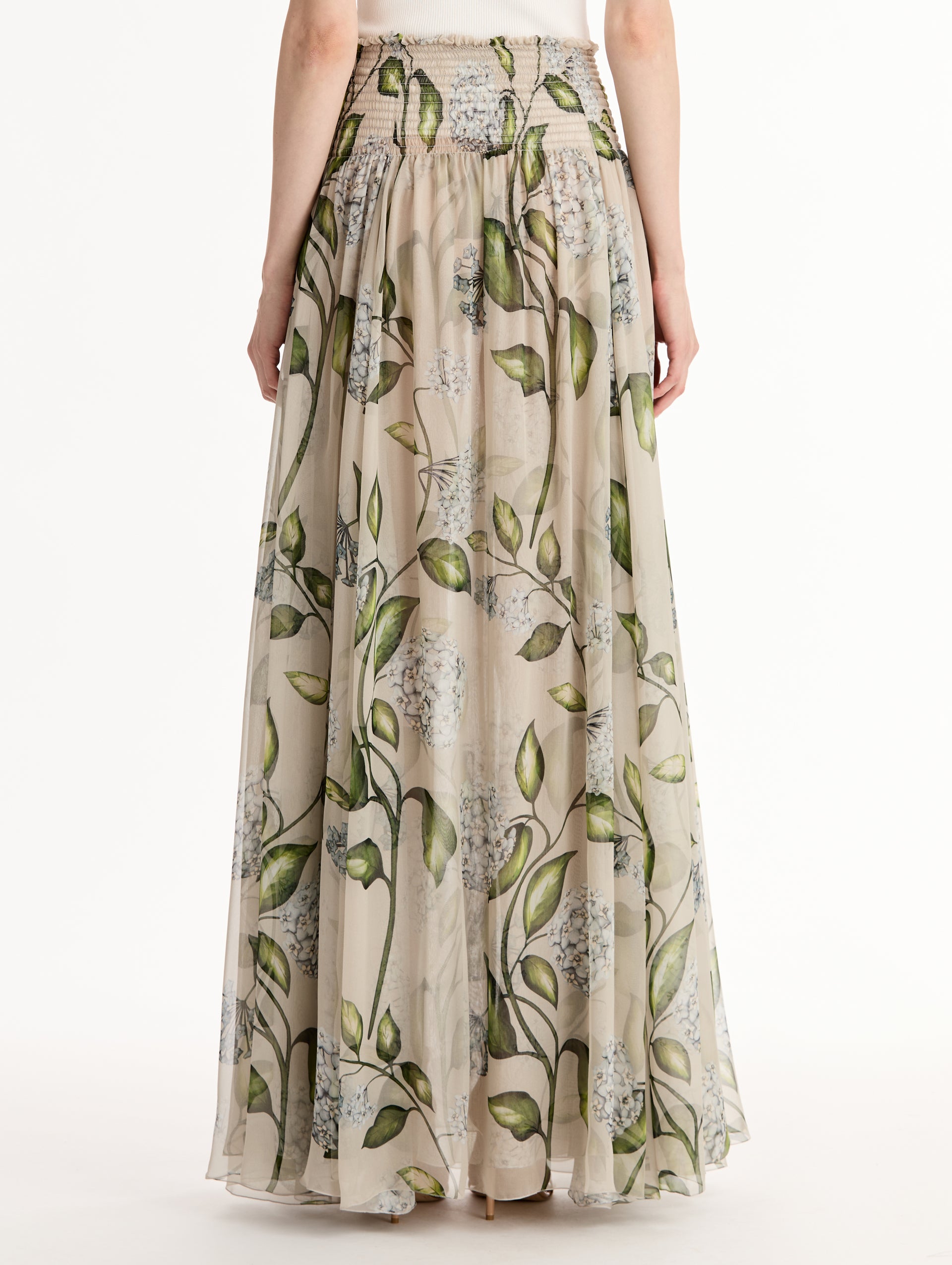 Oatmeal Porcelain Flower Chiffon Maxi Skirt featuring a smocked high waist and a flowing A-line silhouette with green and blue floral print. Back View.