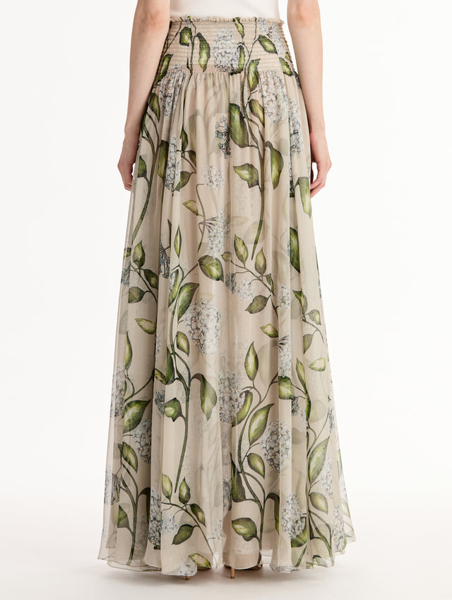 Oatmeal Porcelain Flower Chiffon Maxi Skirt featuring a smocked high waist and a flowing A-line silhouette with green and blue floral print. Back View.