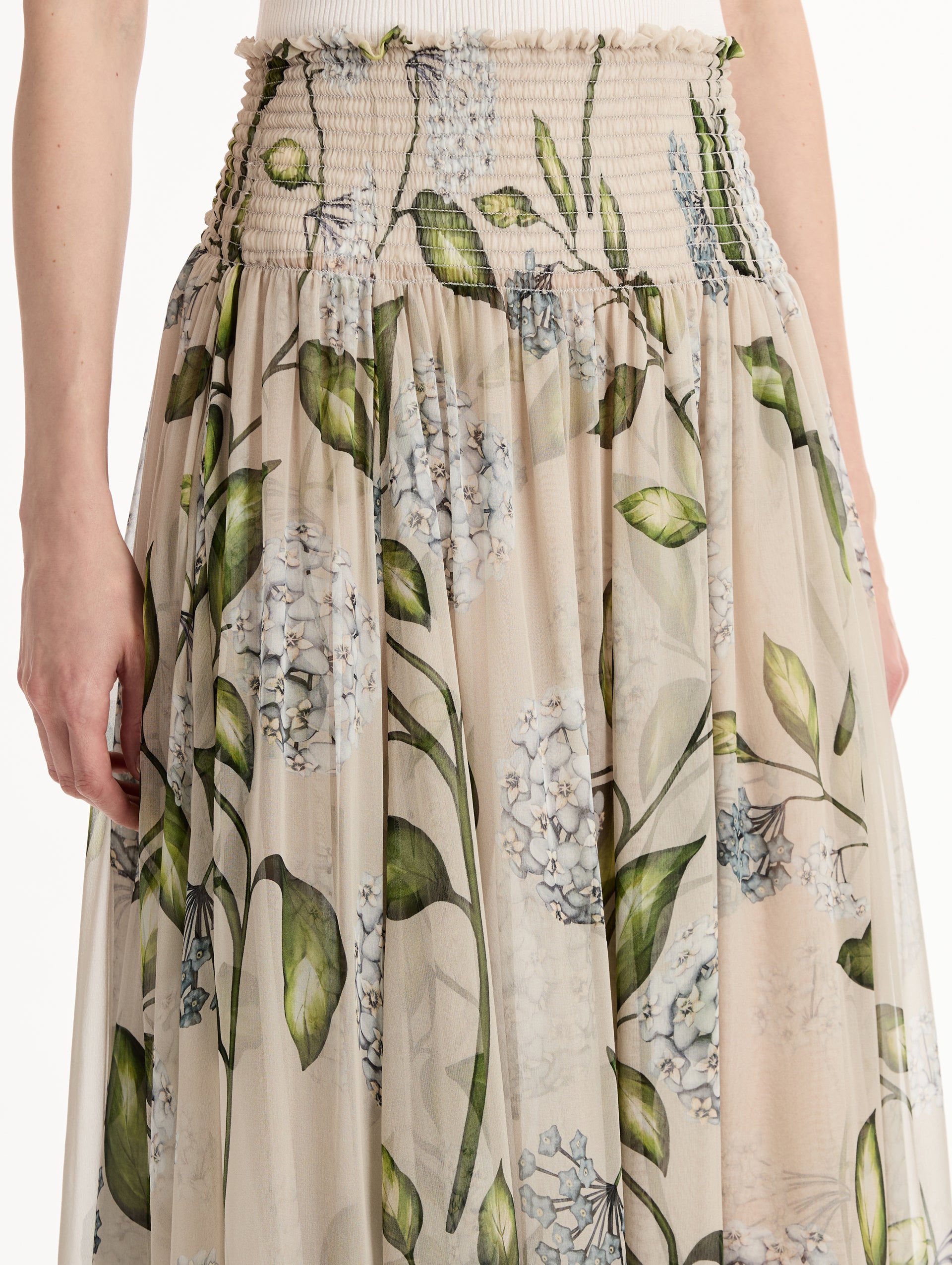 Oatmeal Porcelain Flower Chiffon Maxi Skirt featuring a smocked high waist and a flowing A-line silhouette with green and blue floral print. Zoom View.