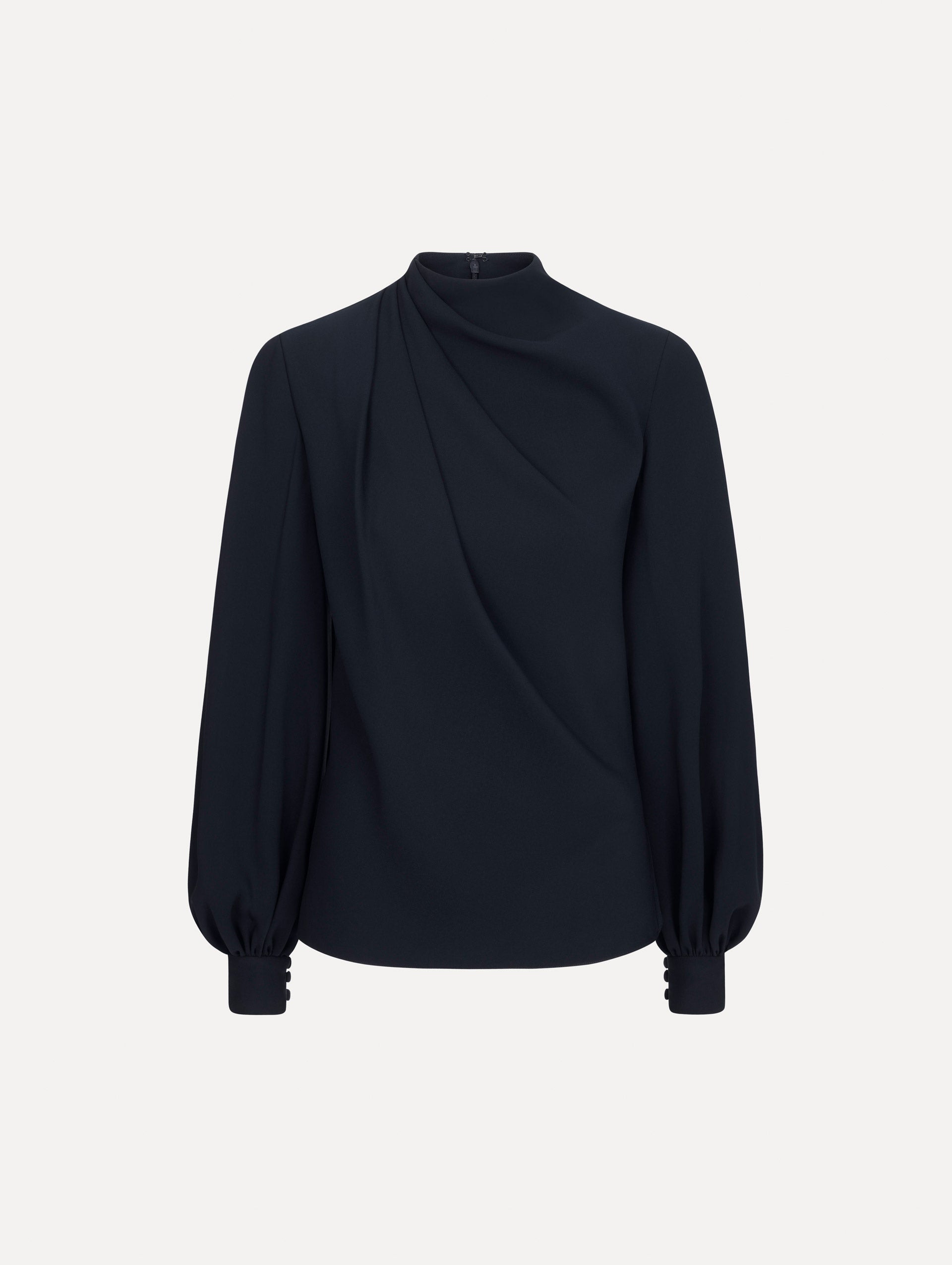 The model is wearing the Draped Georgette Blouse in the color Navy. Featuring silk georgette, a draping mock-neckline, and long, billowed sleeves. Front View.