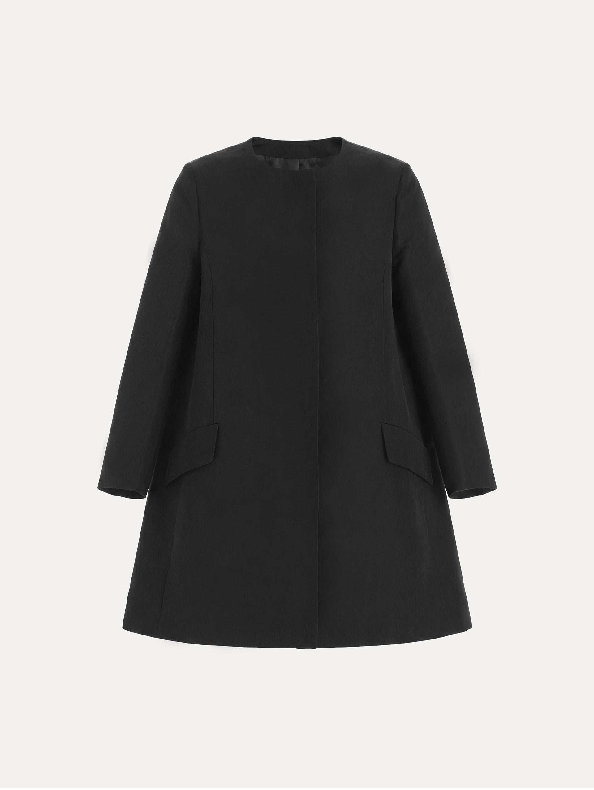 The model is wearing the Silk Faille Short Coat with flap pockets in the color black. 