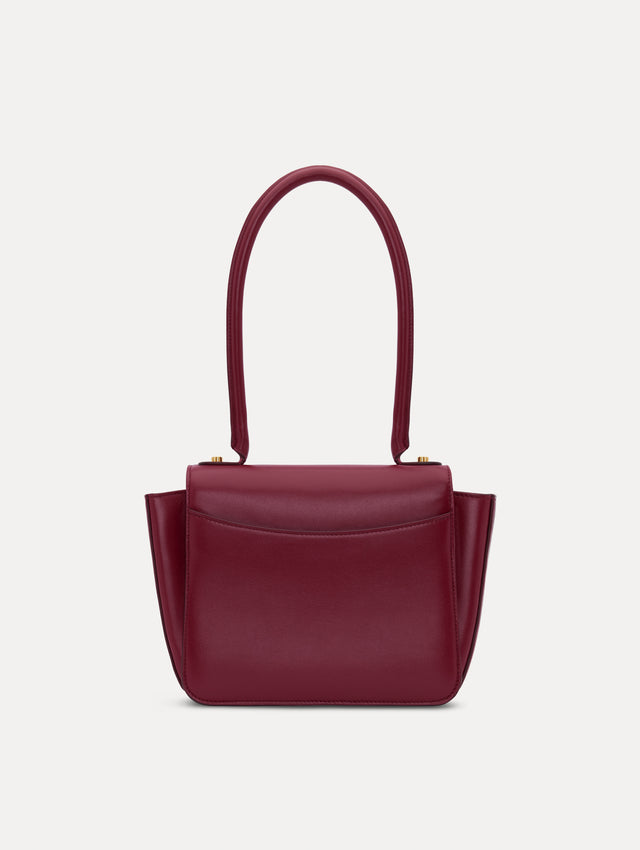 The model is carrying a top handle TRO bag. Back view.