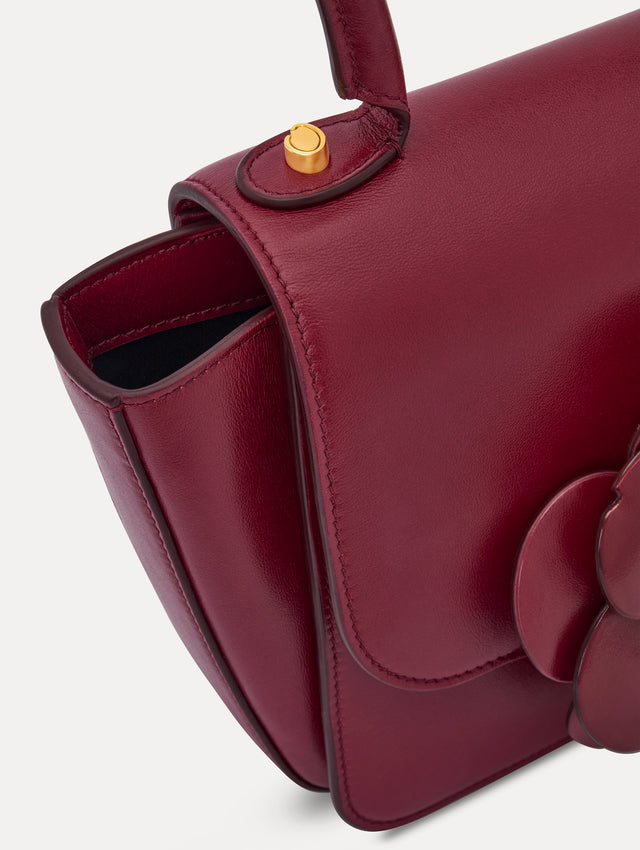 The model is carrying a top handle TRO bag. Side view.