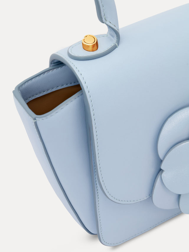 The model is carrying a top handle TRO bag. Back view.